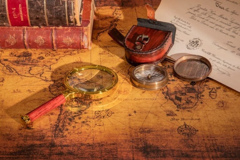 Een vergrootglas, kompas, leren tas, oude boeken en een oude kaart van Afrika van de Koloniale Conferentie van Berlijn (1884-1885) liggen op een tafel naast een handgeschreven document.